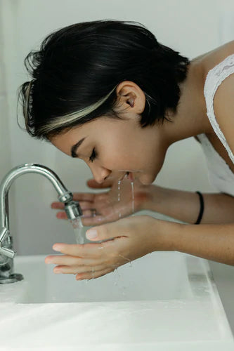 Girl cleansing her face with water
